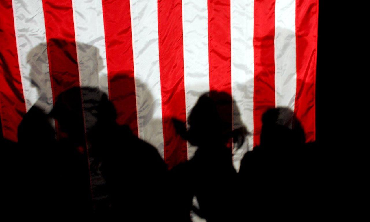 People cast their shadows on an American flag. (Photo by Joe Raedle/Getty Images)