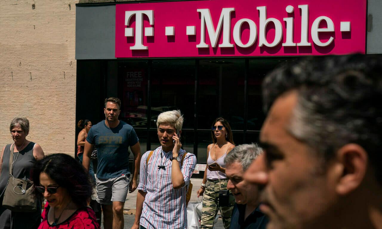 Pedestrians cross an intersection near a T-Mobile store on Sixth Avenue in Manhattan. The company suffered the latest in a series of breaches since its merger with Spring. (Drew Angerer/Getty Images)