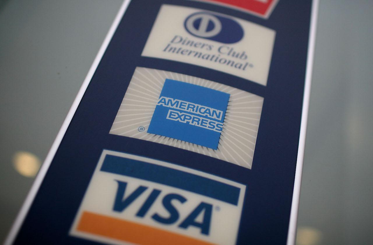 A sign showing credit card logos is seen outside of a bank. (Photo by Justin Sullivan/Getty Images)