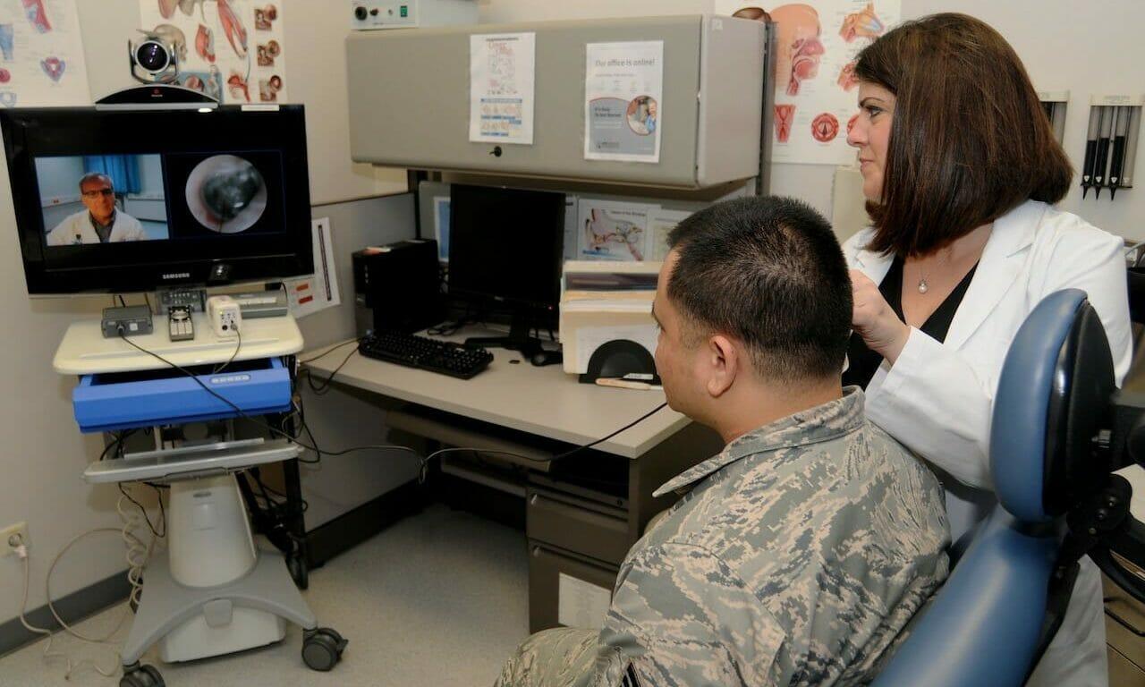 A nurse with the Telehealth Program at Landstuhl Regional Medical Center demonstrates using a telehealth cart otoscope to conduct a real-time tympanic membrane exam with a physician on screen from a remote location. (&#8220;Telehealth Makes Possible Long Distance Medical Appointments&#8221; by Army Medicine is licensed under CC BY 2.0)