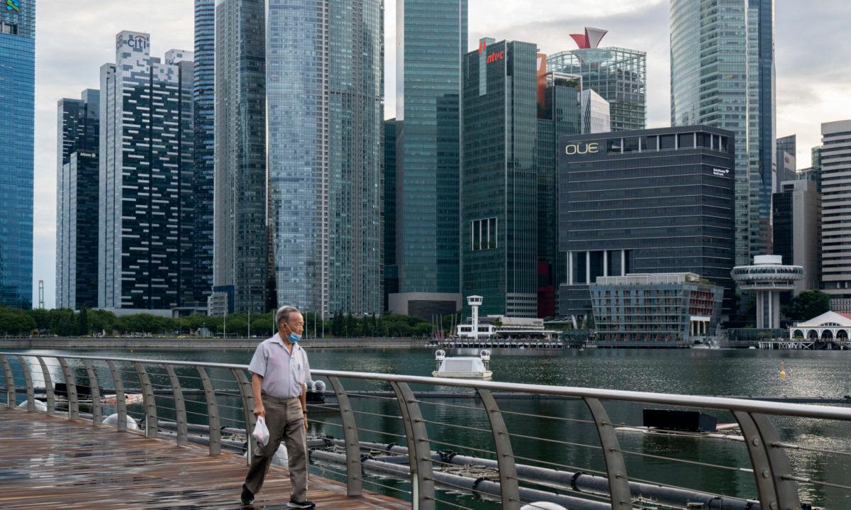 SINGAPORE, SINGAPORE &#8211; JULY 07: A man wearing a protective mask walks past the Marina Bay Sands Shopping Center with the central business district in the background on July 07, 2020 in Singapore. A trio of cybersecurity agreements with Singapore governments could boost cyber cooperation with an increasingly crucial Asia tech and security part...
