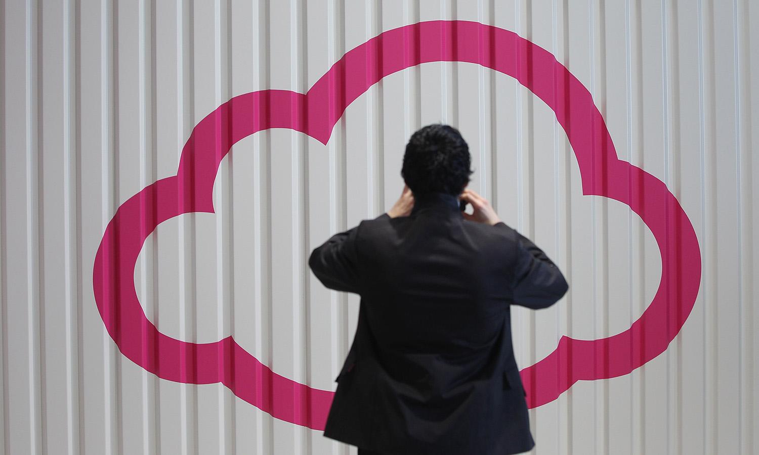 A visitor photographs a symbol of a cloud at the Deutsche Telekom stand the day before the CeBIT 2012 technology trade fair officially opens to the public on March 5, 2012, in Hanover, Germany.(Photo by Sean Gallup/Getty Images)