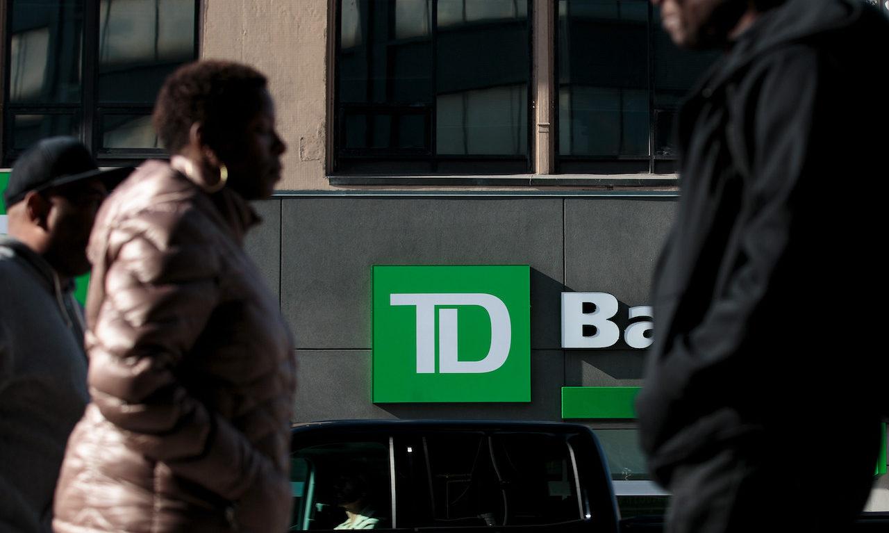 People walk past a TD Bank in the Brooklyn borough of New York City. Earlier this month, a federal grand jury indicted three men for their alleged role in a business email compromise scam, including a former employee of both TD Bank and Bank of America. (Photo by Drew Angerer/Getty Images)