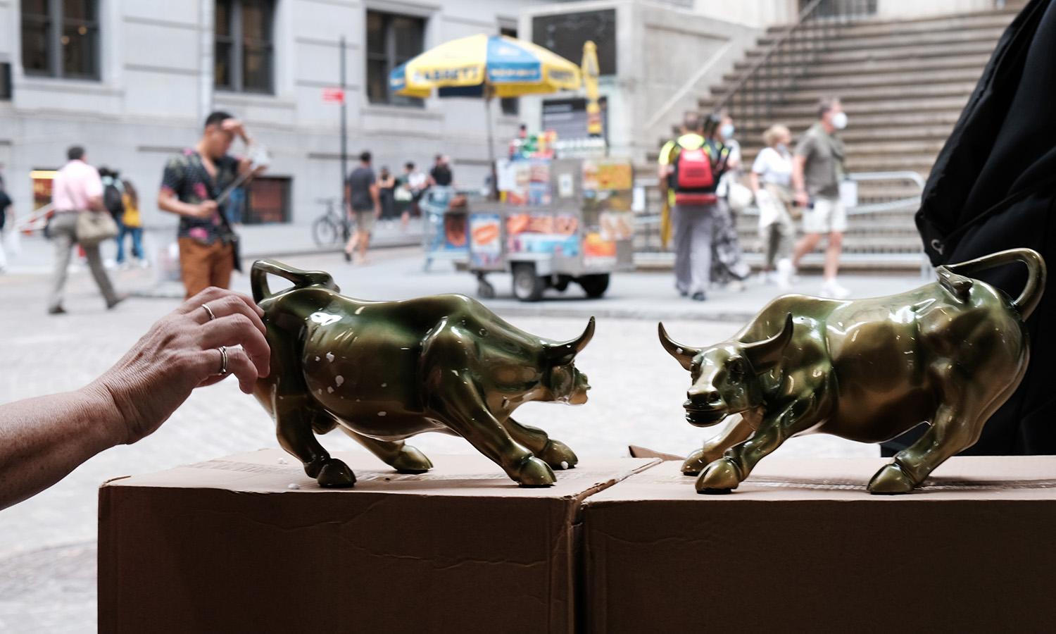 A vendor sells replicas of the Wall Street Bull outside of the New York Stock Exchange (NYSE) on Sept. 16, 2021, in New York City.  (Photo by Spencer Platt/Getty Images)