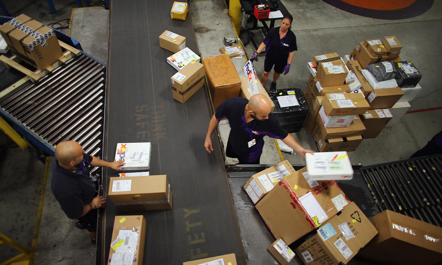 Sansec researchers say Linux-based malware attacking e-commerce servers is taking commands from a control service in Beijing. Pictured: FedEx employees sort through items being shipped through the Fedex World Service Center on Dec. 10, 2012, in Doral, Fla. (Photo by Joe Raedle/Getty Images)