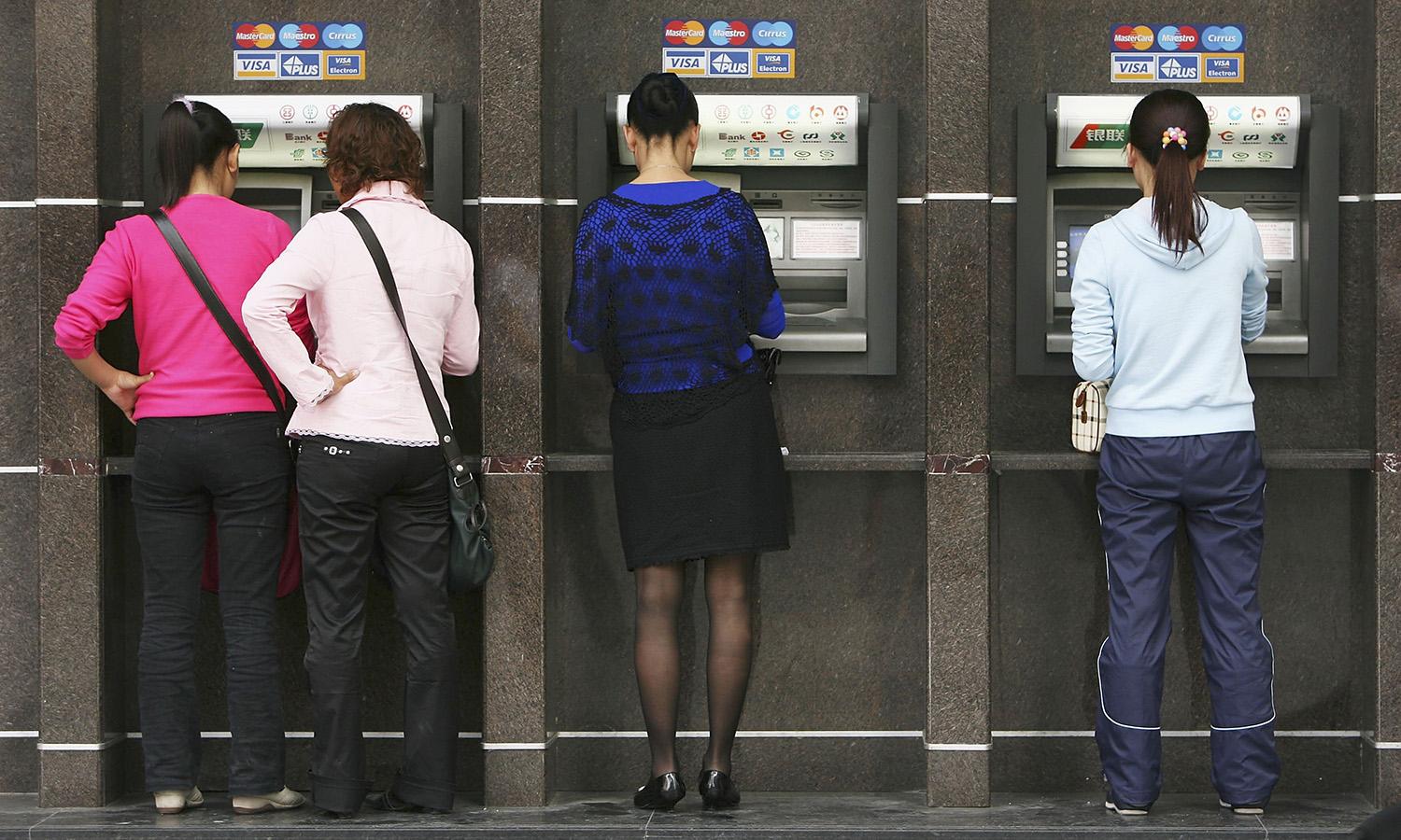 A ransomware attack on HR vendor Kronos has created payroll issues for healthcare employees. Pictured: People draw money from automatic teller machines at a street on April 3, 2006, in Chongqing Municipality, China. (Photo by China Photos via Getty Images)