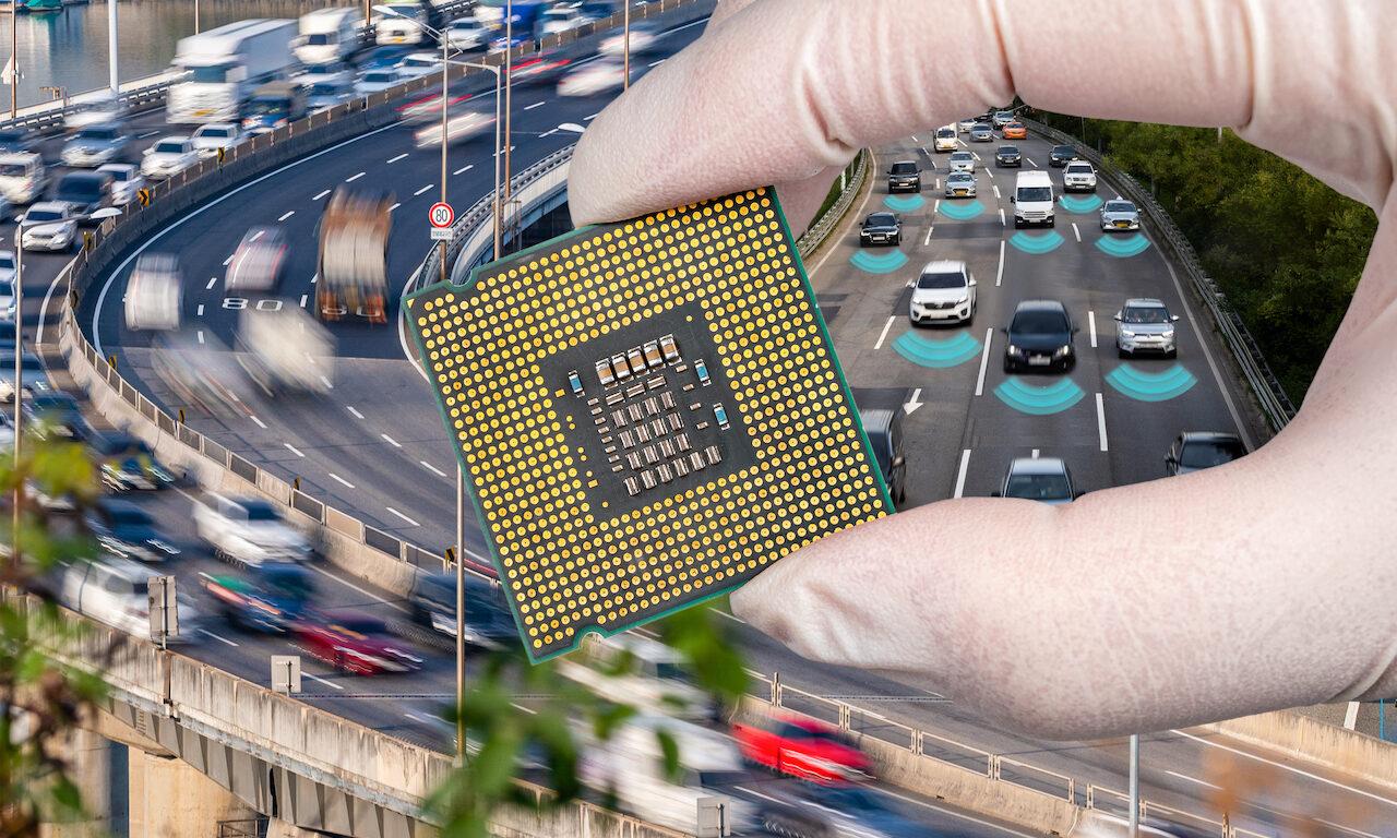 The computer circuit board and fast-moving cars. A hand holding a CPU chipset.