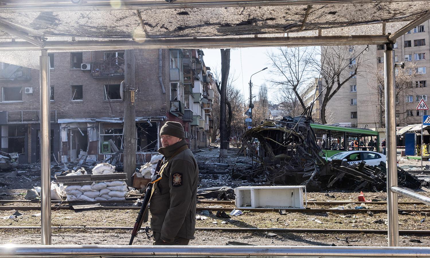 A member of the Ukrainian military stands amid debris from a damaged residential apartment block caused after a Russian rocket was shot down by Ukrainian air defenses on March 14, 2022, in Kyiv, Ukraine. (Photo by Chris McGrath/Getty Images)
