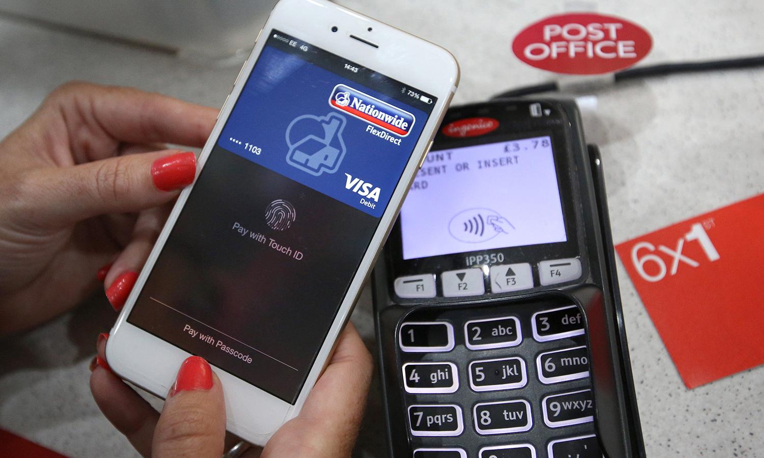 The growth of digital transactions provide fraudsters another avenue to target, according to a LexisNexis report. Pictured: An iPhone is used to make an Apple Pay purchase at the Post Office on July 14, 2015, in London. (Photo by Peter Macdiarmid/Getty Images)