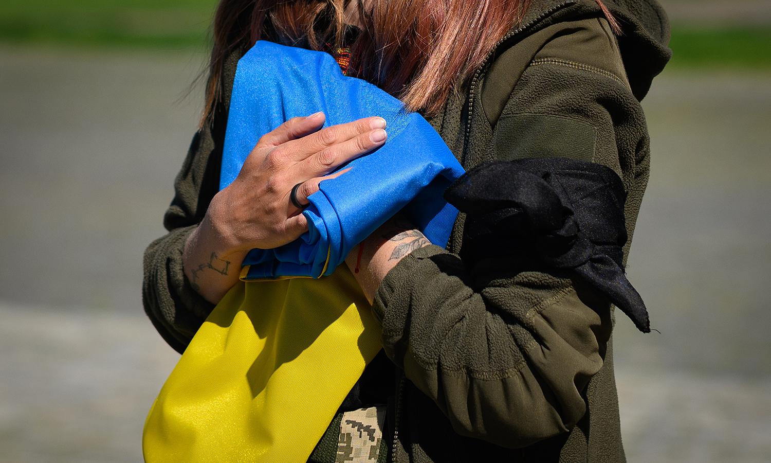 The U.S., U.K. and E.U. condemned Russia for a February cyberattack on the Viasat KA-SAT internet service in Ukraine. Pictured: Vira Moisenko mourns after being handed the Ukrainian flag from the coffin during the funeral of her husband Olexandr Moisenko in the Field of Mars at Lychakiv cemetery on May 10 in Lviv, Ukraine. (Photo by Leon Neal/Getty...