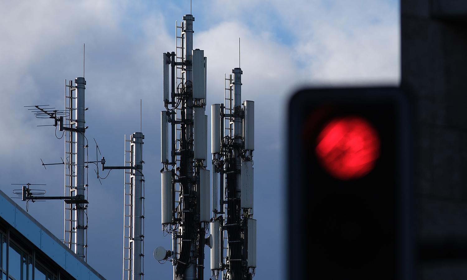 A traffic light shows red under a cellular phone tower that stands on top of an office building on Jan. 2, 2019, in Berlin. (Photo by Sean Gallup/Getty Images)
