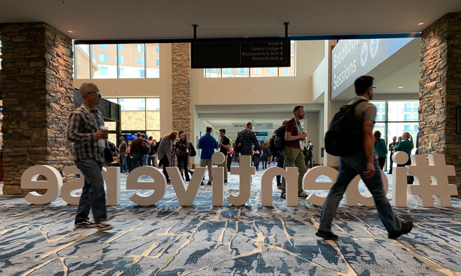 Visitors walk past a sign for the Identiverse Conference in Denver. (Joe Uchill/SC Media)