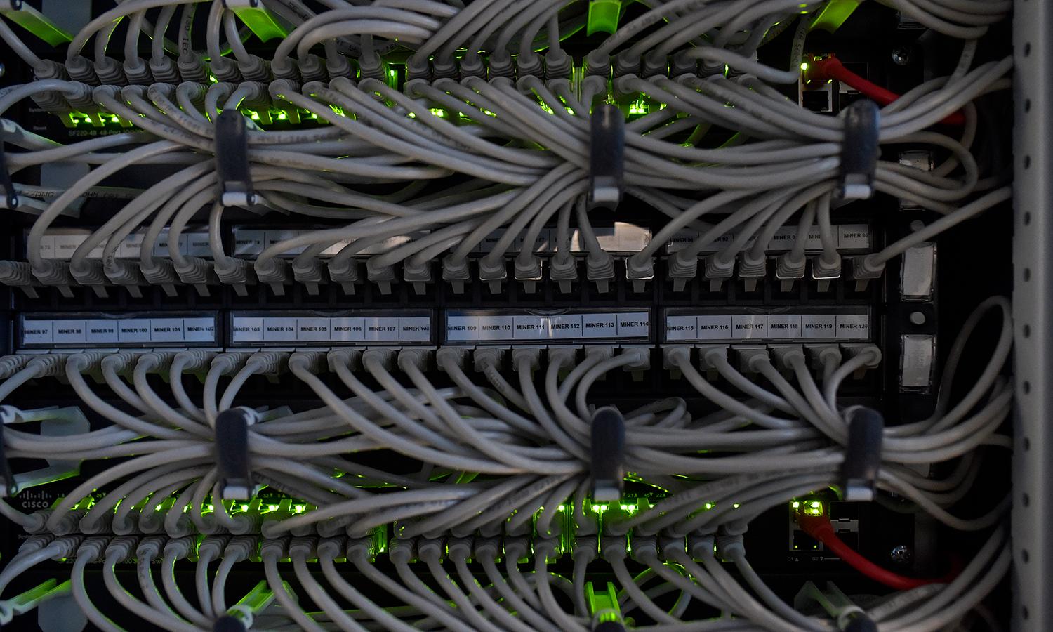 A technical system engineer and hardware asset manager performs control-and-maintenance operations of a cryptomining farm installed inside a hydroelectric power plant on Feb. 2, 2022, in Bolzano, Italy. (Photo by Alessio Coser/Getty Images)
