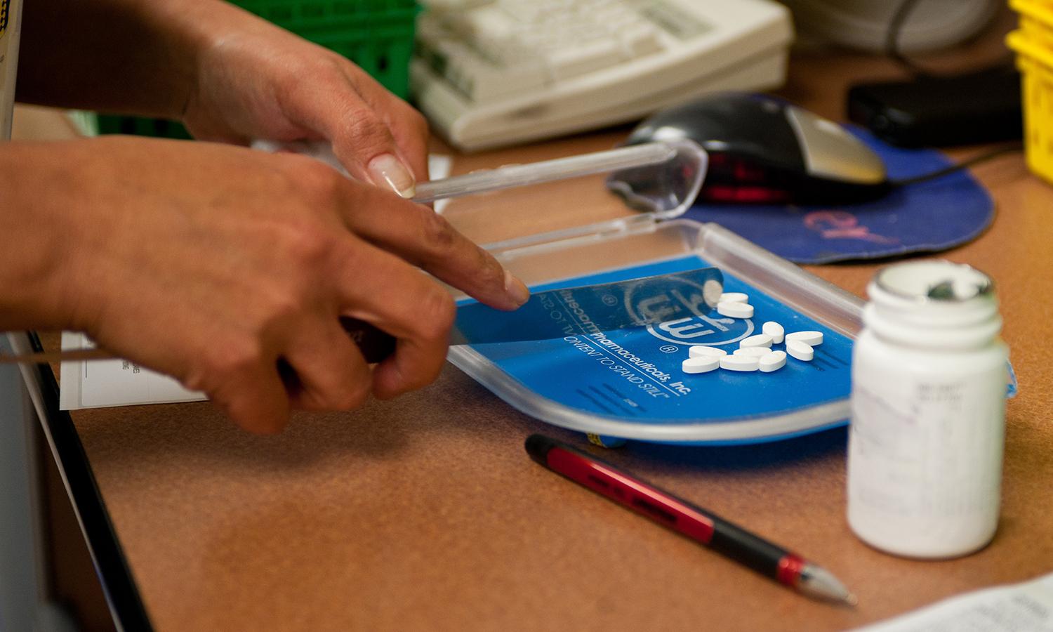 A pharmacy technician counts pills to fill a prescription.