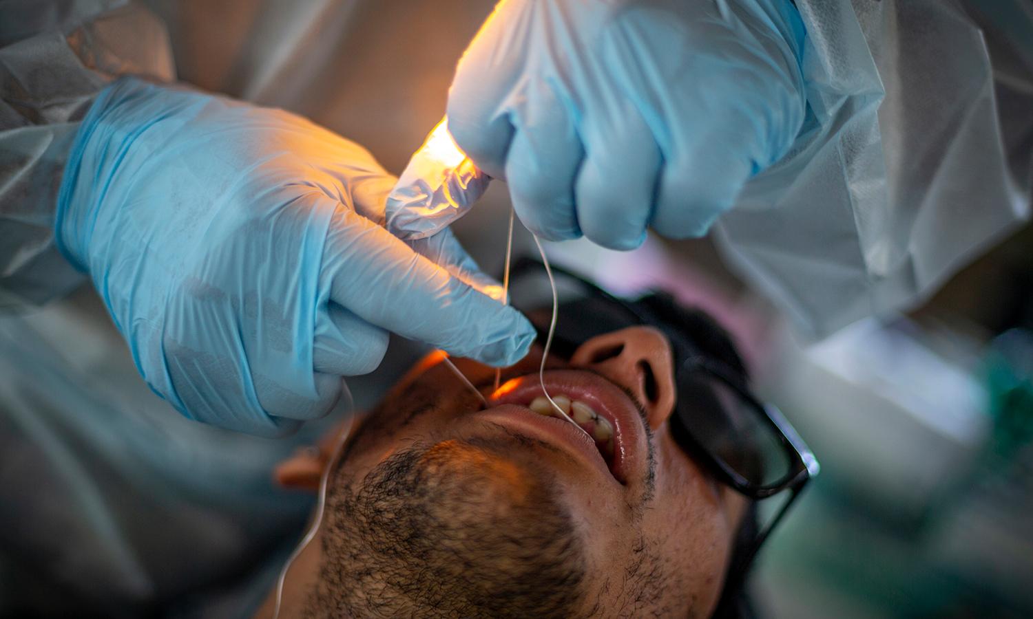 A dental patient receives a flossing.
