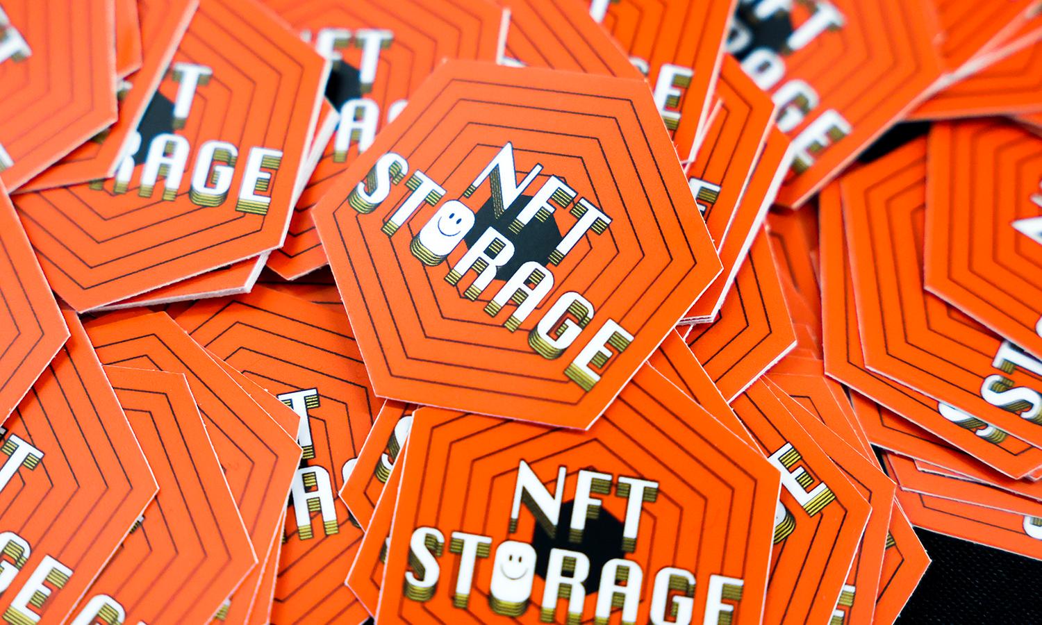 Orange stickers with the words "NFT storage" written in white sit in a pile.