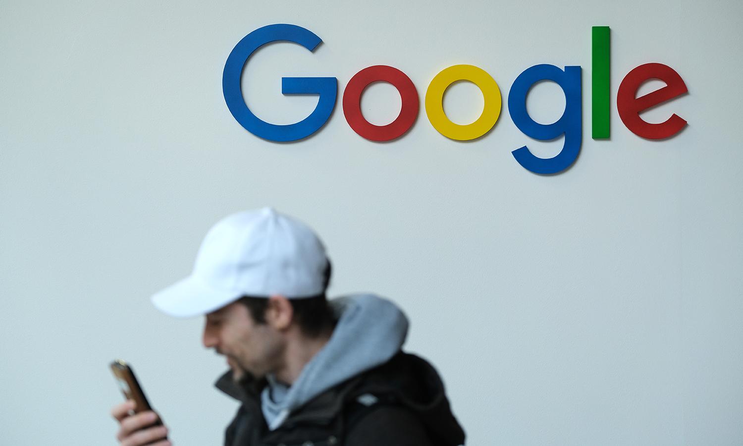 A visitor speaks into a smartphone while standing next to a Google stand on May 6, 2019, in Berlin. (Photo by Sean Gallup/Getty Images)