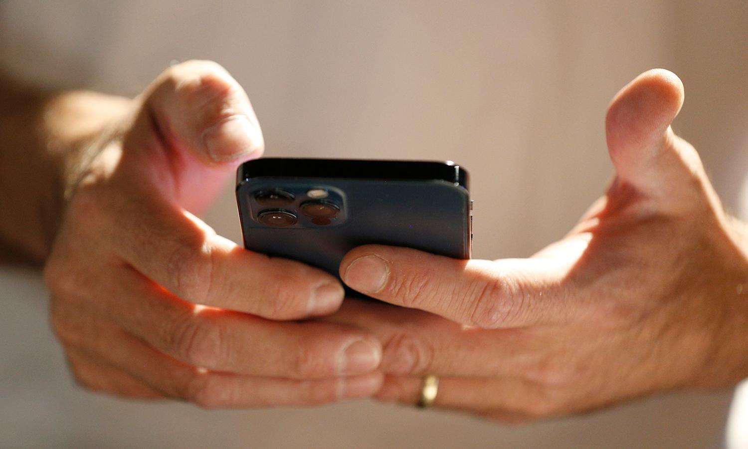 A man uses a smartphone to scan and download an app