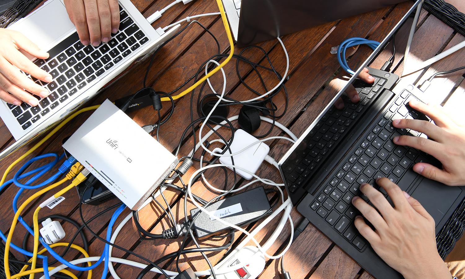 Military cyber warfare operators work on laptops