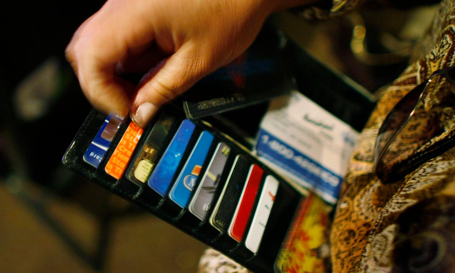 A woman looks in her wallet for credit cards.