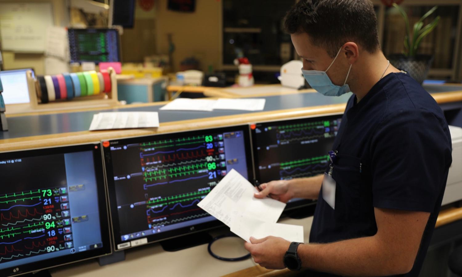 A nurse monitors patient vital signs