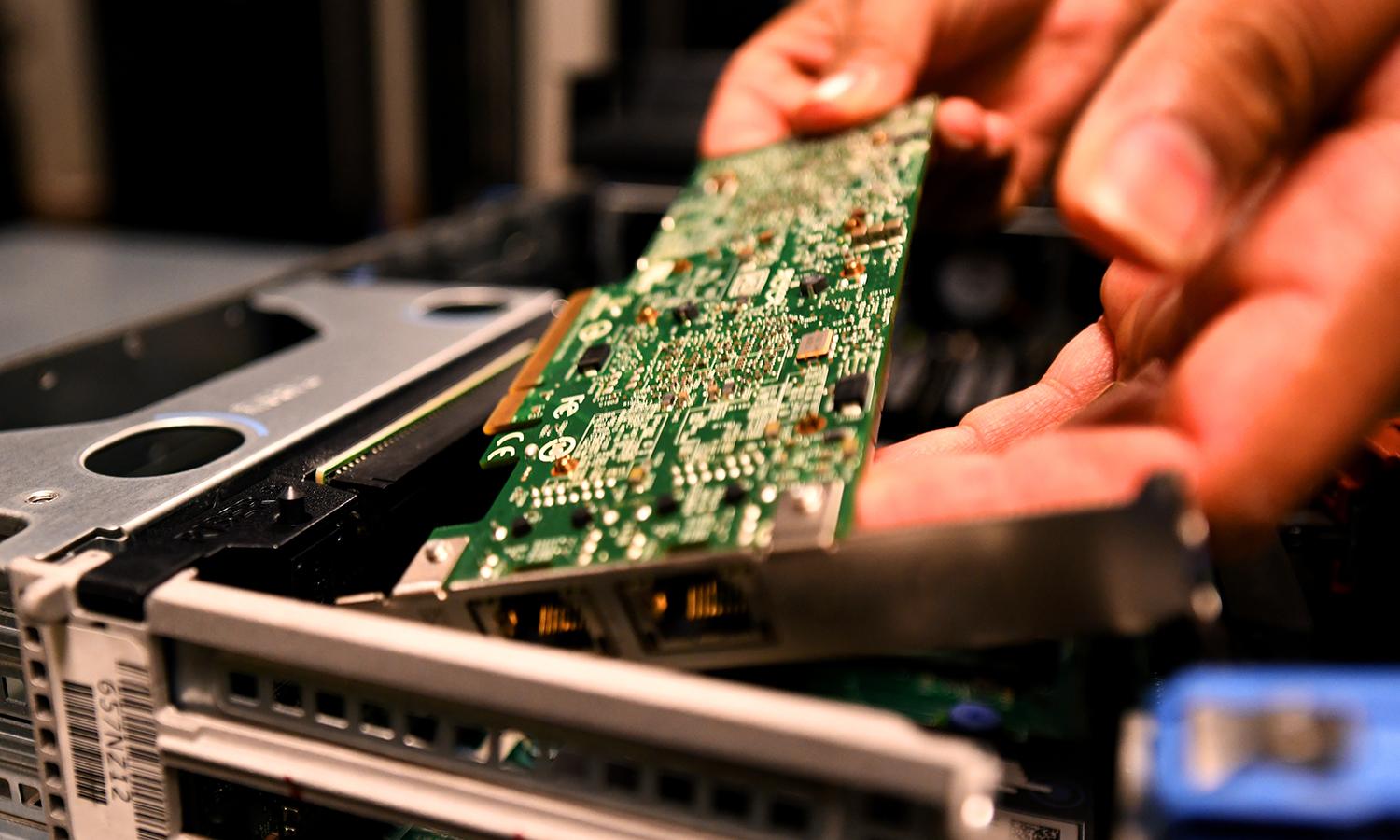 A technician replaces a computer circuit board