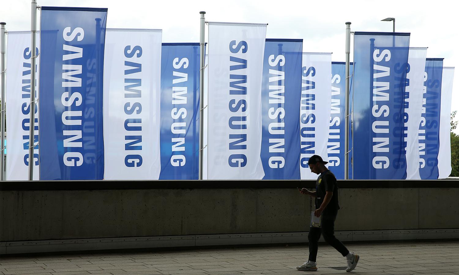 An employee passes Samsung flags