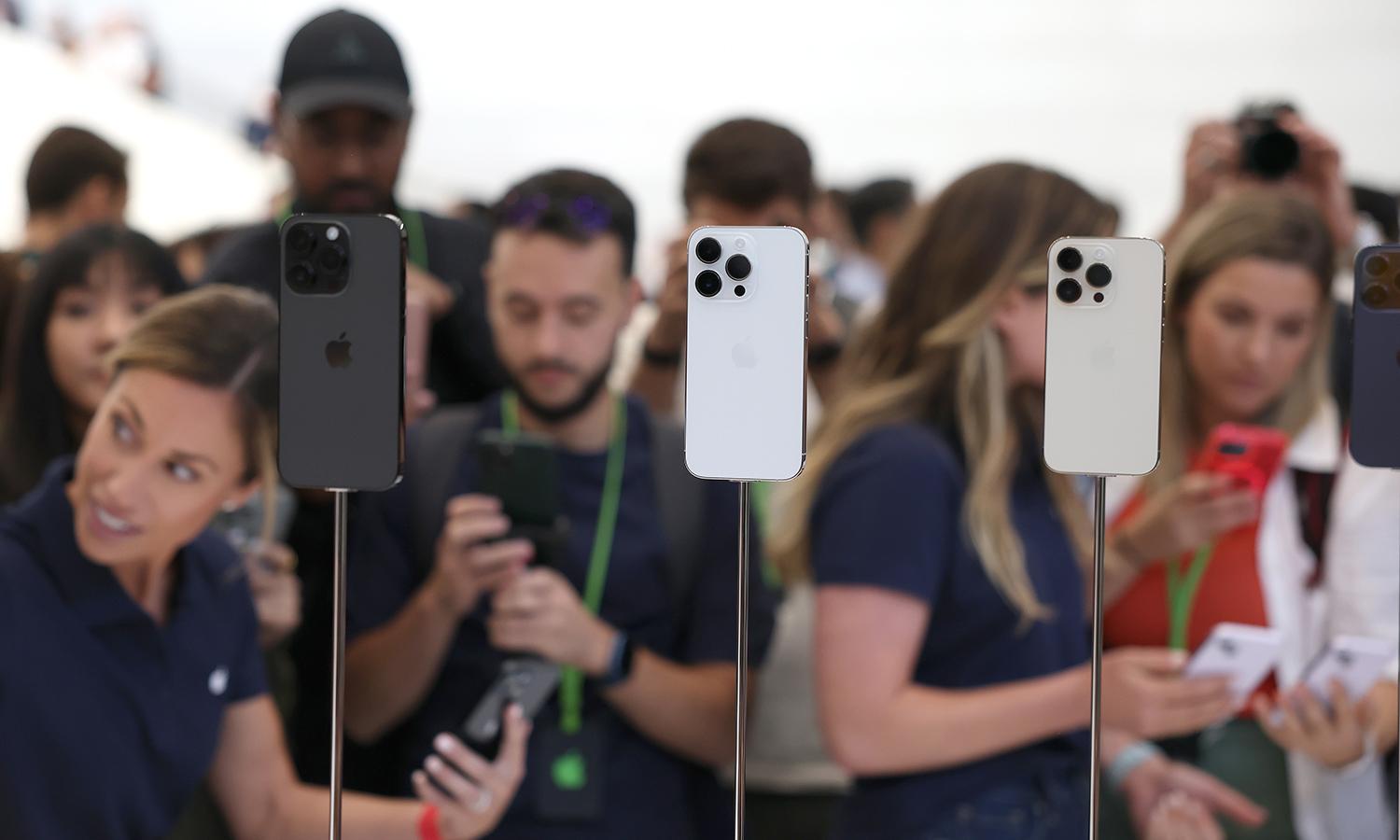 New iPhone 14 Pros are displayed on stands at an event