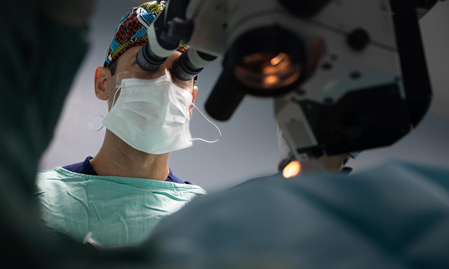 An ophthalmologist performs surgery on a patient