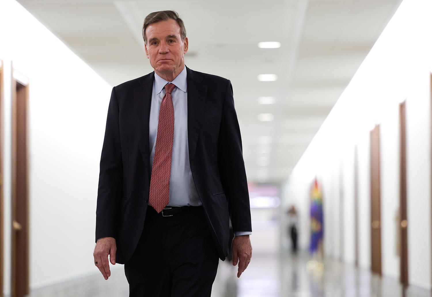 Sen. Mark Warner walks down a hallway on Capitol Hill