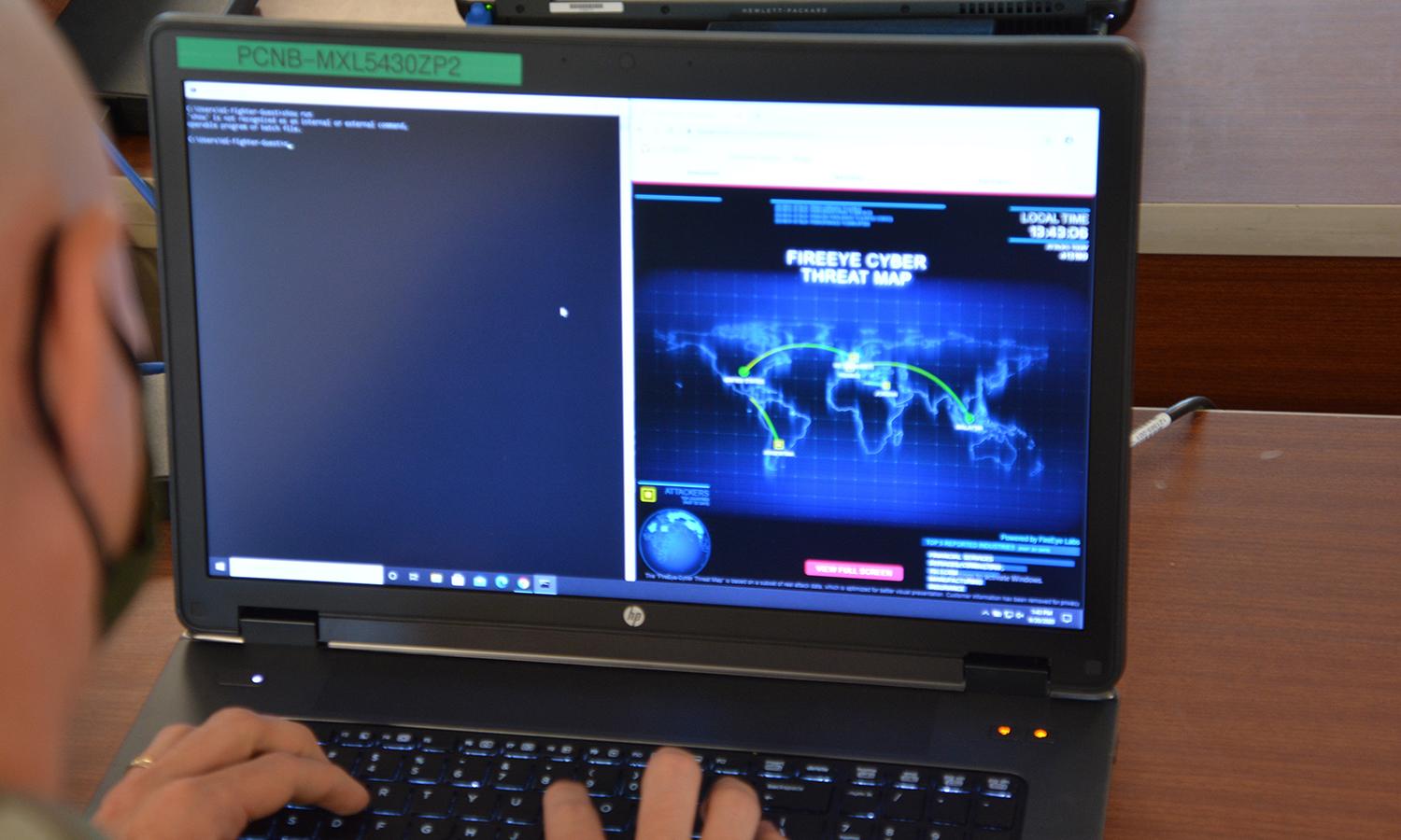 A soldier participates in a cybersecurity exercise using a laptop computer