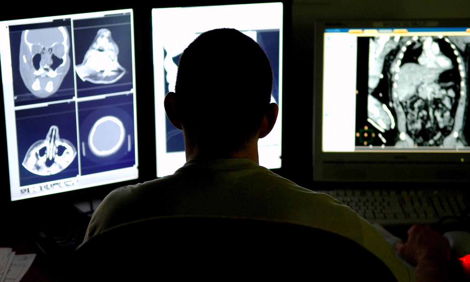 An Air Force radiologist reviews CT scans from a trauma patient.