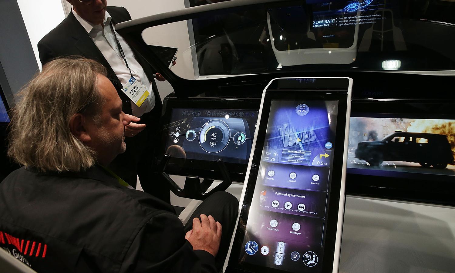 Show attendees check out a prototype of a connected car console at a consumer technology trade show