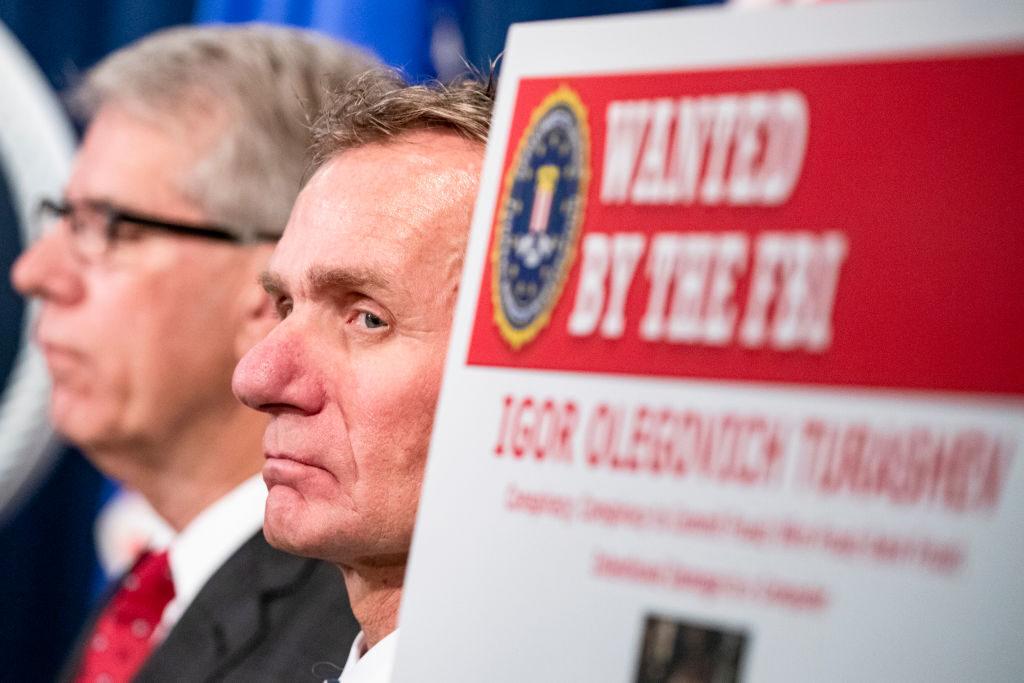 A law enforcement official listens as U.S. and U.K. Law enforcement officials announce warrants for the arrests of Maksim Viktorovich Yakubets and Igor Olegovich Turashev, two Russian hackers associated with a group called Evil Corp., at the U.S. Department of Justice on December 5, 2019 in Washington, DC. A new study seeks to draw out the specific...