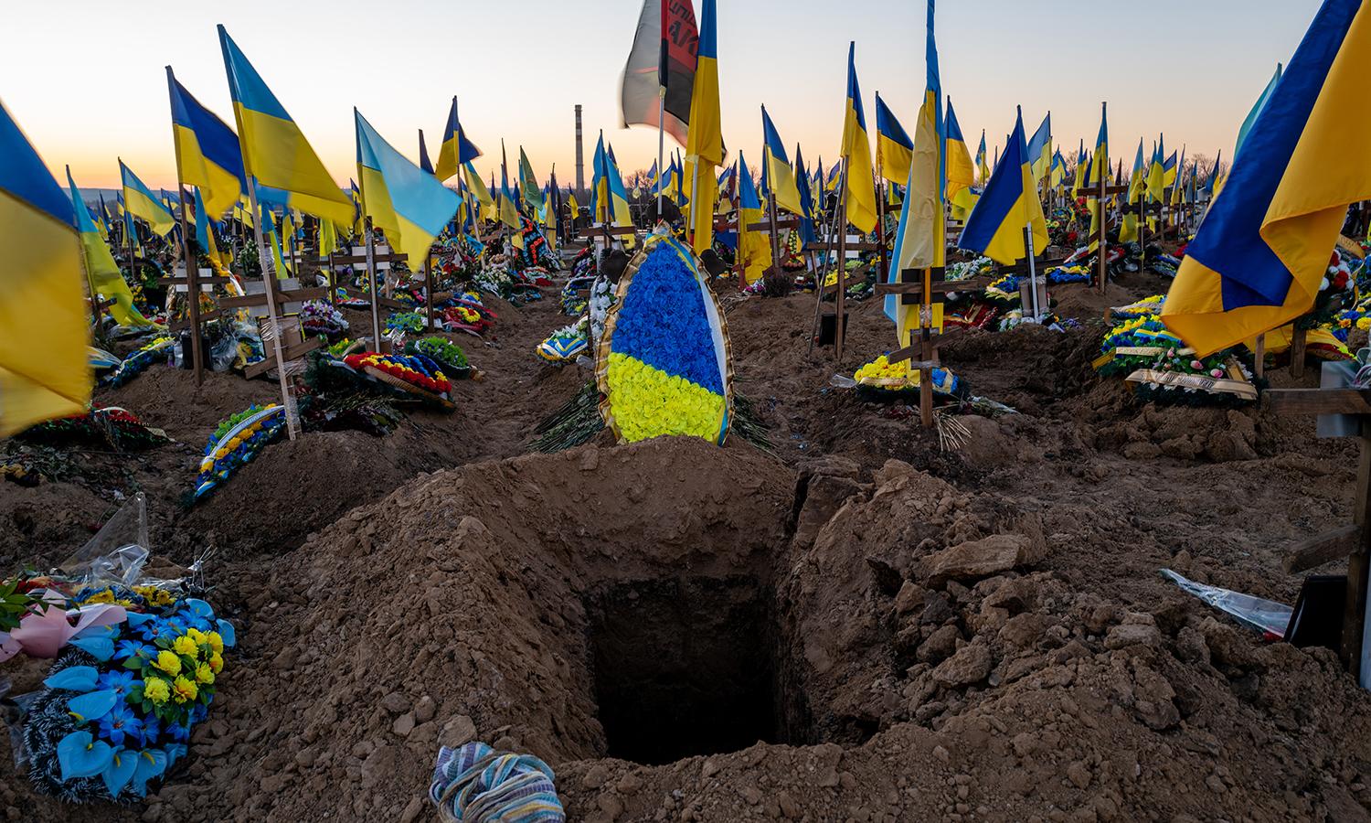 Ukrainian flags displayed at a cemetery