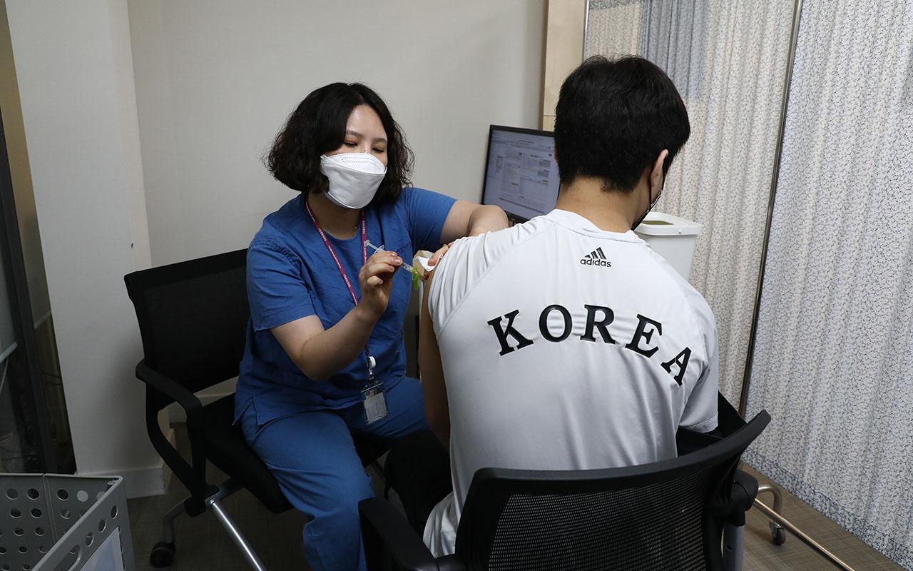 A South Korean athlete gets a COVID vaccine shot