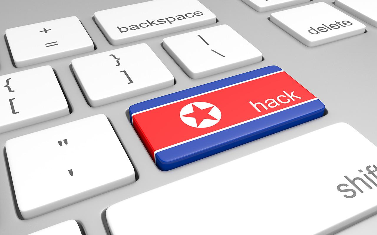 North Korea hacking concept of a computer keyboard and a key painted with the North Korean flag